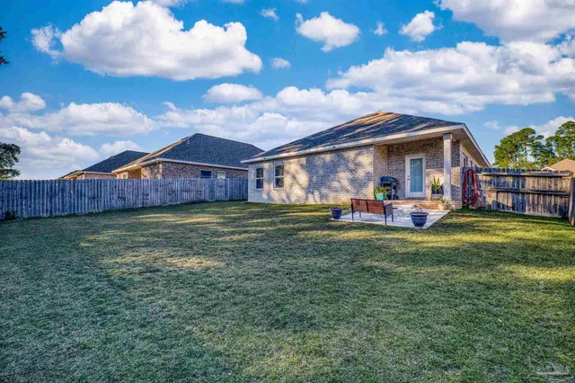 a view of a house with a big yard and a large tree