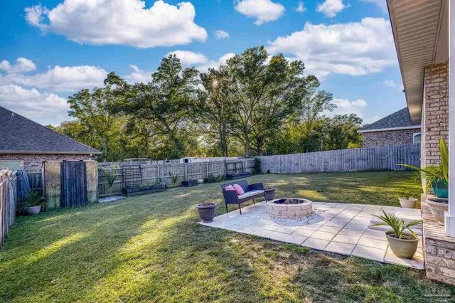 a view of a backyard with swimming pool and furniture