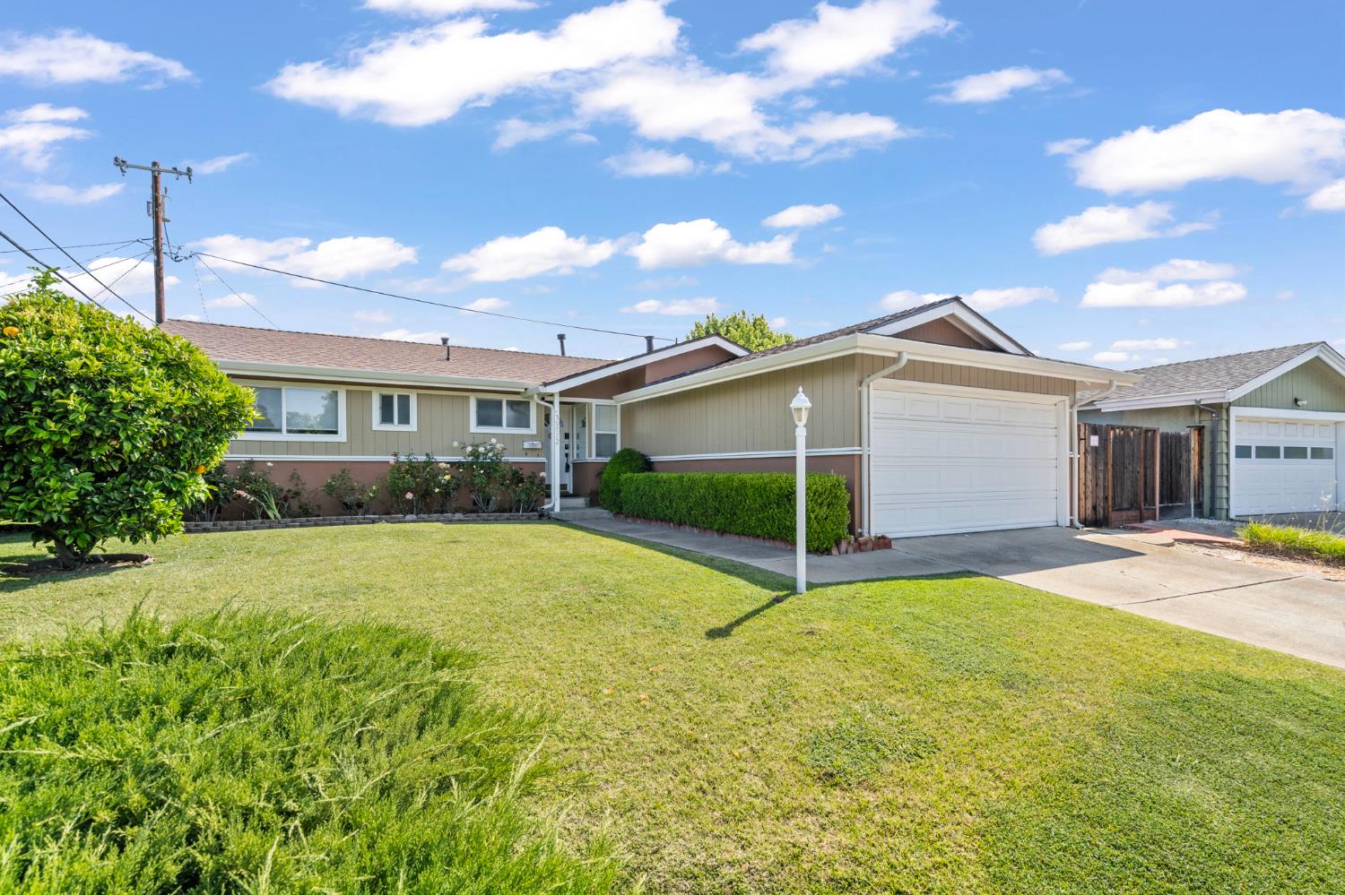 a view of a house with a yard and tree