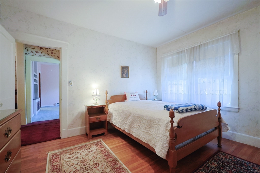 587 Common Street Walpole, MA 02081 - Photo 14 of 38 a bed room with a bed and a couch