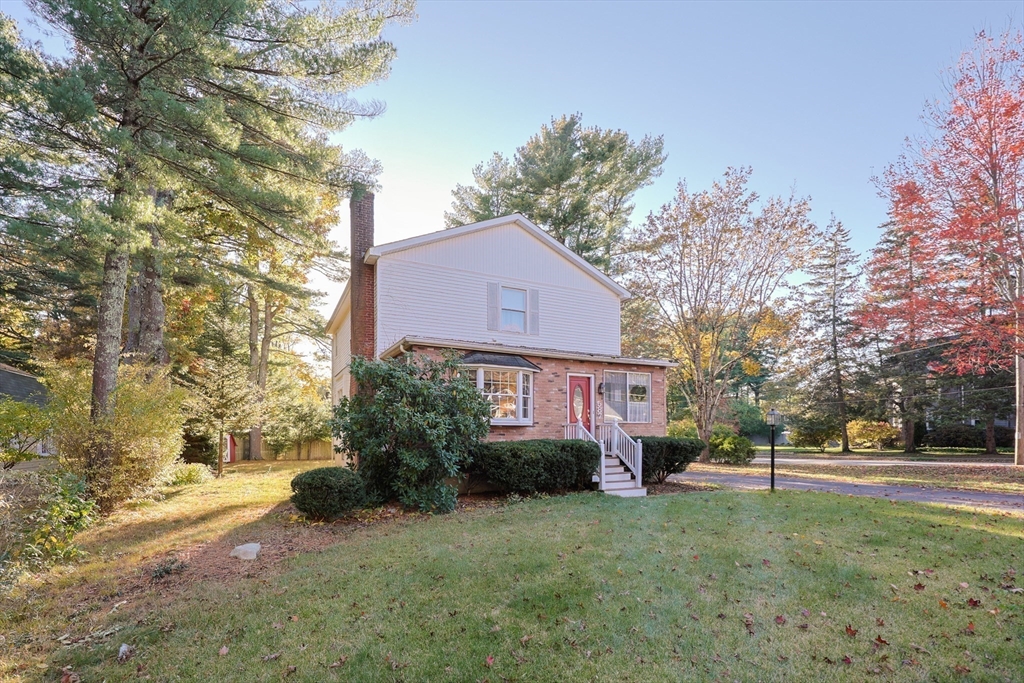 587 Common Street Walpole, MA 02081 - Photo 2 of 38 a front view of a house with a yard and trees