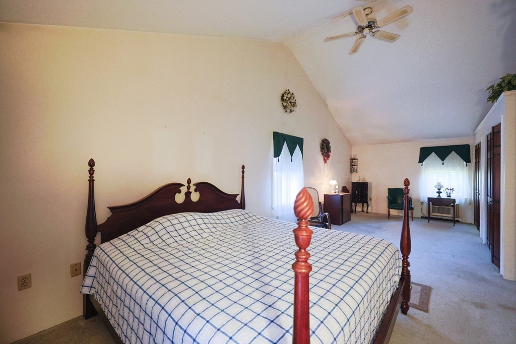 587 Common Street Walpole, MA 02081 - Photo 30 of 38 a bedroom with a bed and a chandelier