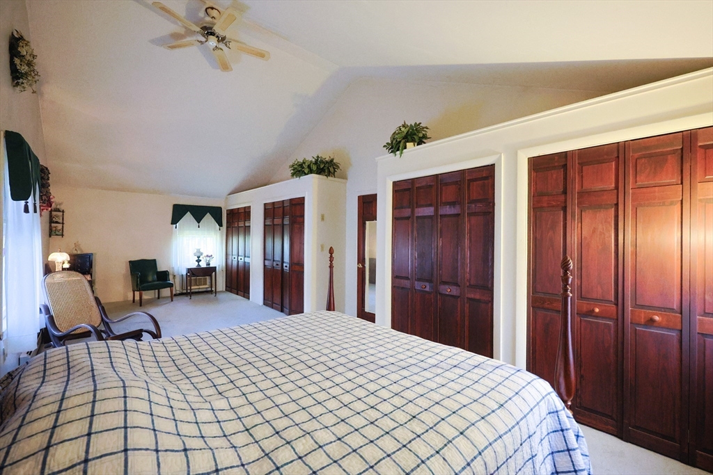 587 Common Street Walpole, MA 02081 - Photo 31 of 38 a bed room with a bed and a mirror