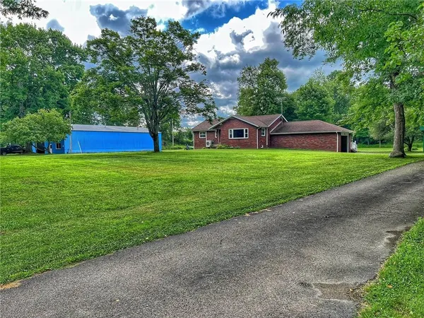 a front view of a house with a garden and yard