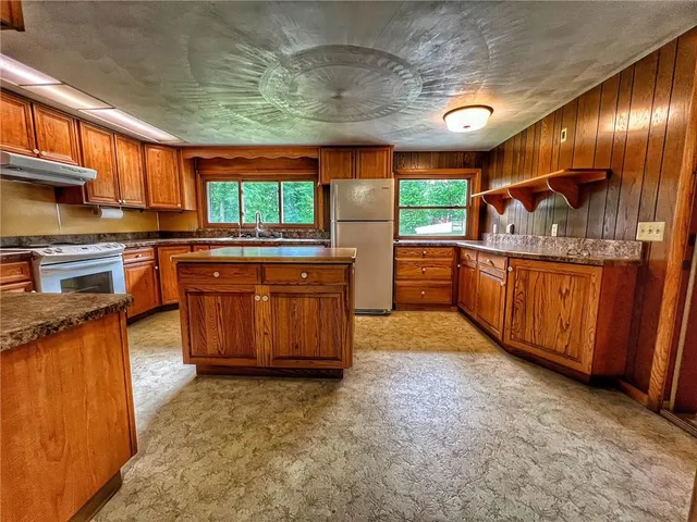 a kitchen with stainless steel appliances granite countertop a stove a sink and a refrigerator