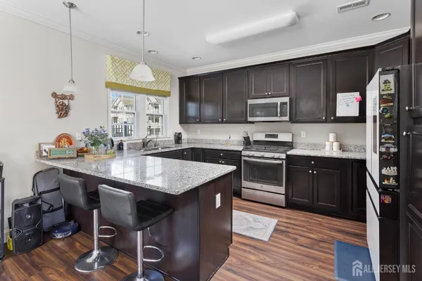 a kitchen with stainless steel appliances granite countertop a sink a stove and a refrigerator