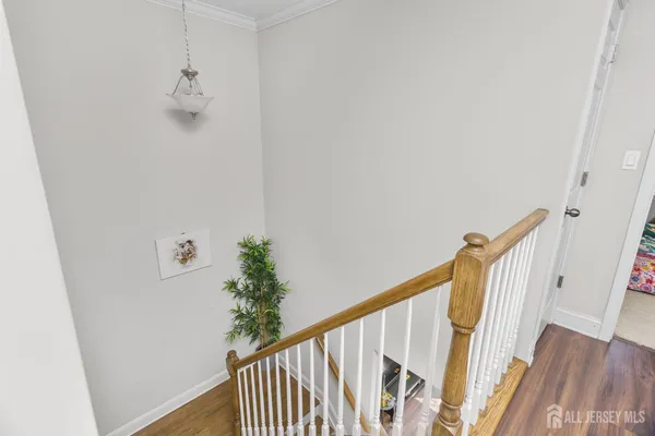 a view of a hallway with wooden floor and stairs