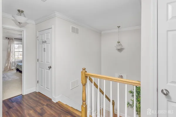 a view of a hallway with wooden floor and closet area
