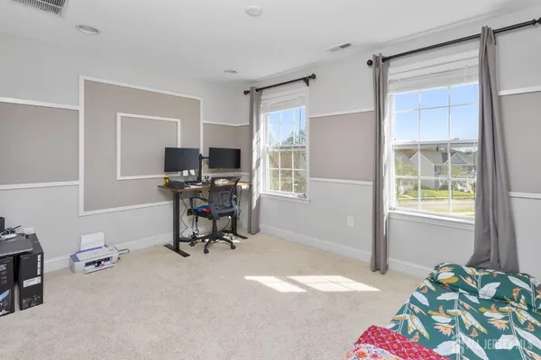 a view of a workspace with furniture and a window