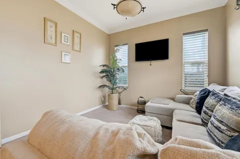 a bedroom with furniture a flat screen tv and a window