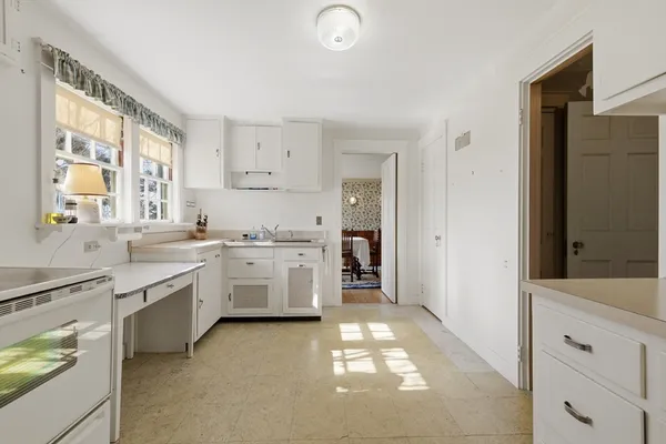 a kitchen with white cabinets and white appliances