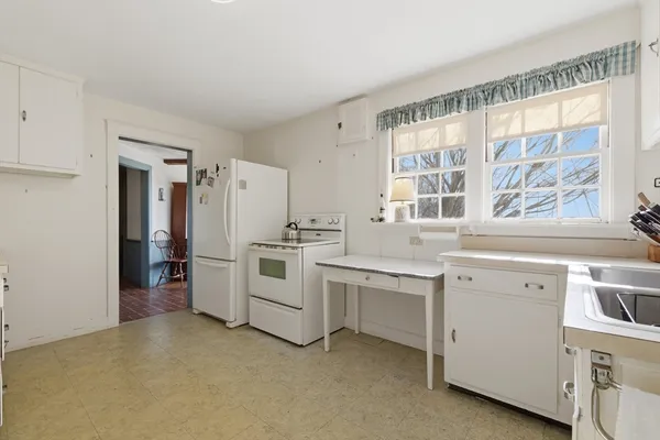 a kitchen with white cabinets and white appliances