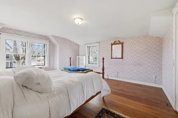 a bedroom with a bed and a large window