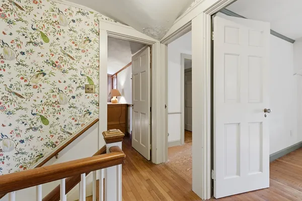 a view of a hallway with wooden floor and staircase