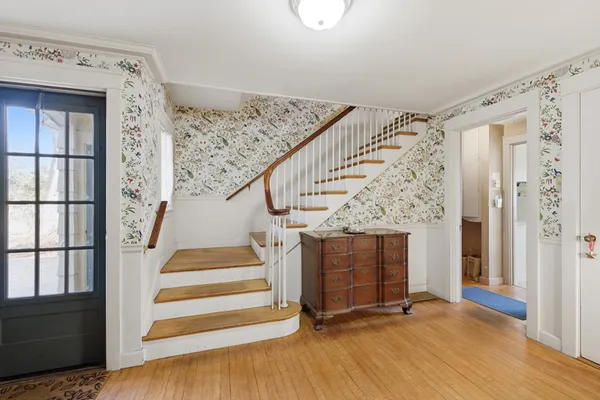 a view of entryway and hall with wooden floor