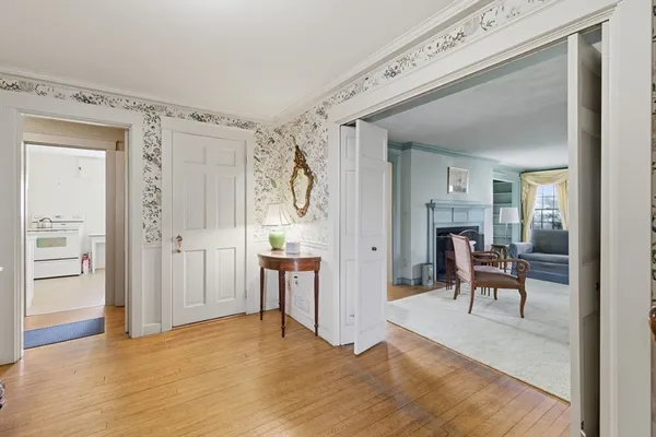 a view of a hallway with wooden floor and a cabinet