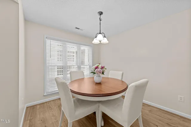 a dining room with furniture a chandelier and wooden floor