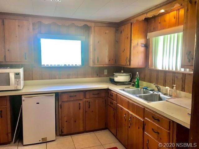 204 Hubbell Street Edgewater, FL 32132 - Photo 2 of 14 a kitchen with a sink window and cabinets