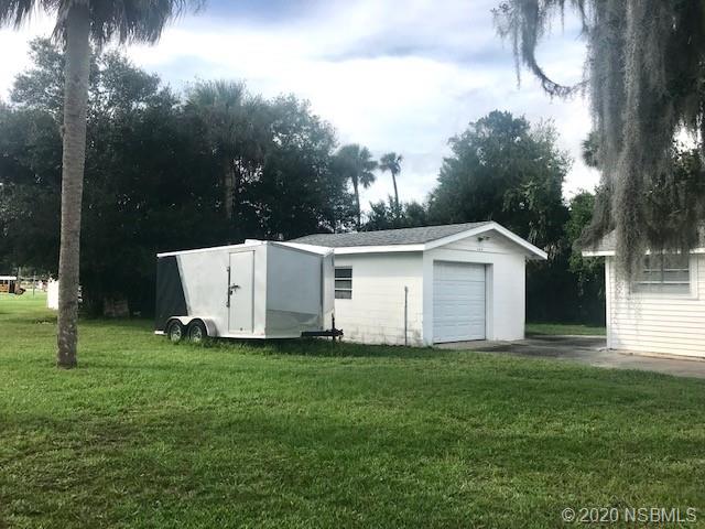 204 Hubbell Street Edgewater, FL 32132 - Photo 11 of 14 a view of a white house with a big yard and a large tree