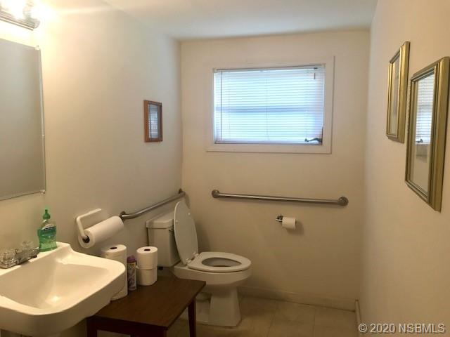 204 Hubbell Street Edgewater, FL 32132 - Photo 5 of 14 a bathroom with a toilet a sink and mirror