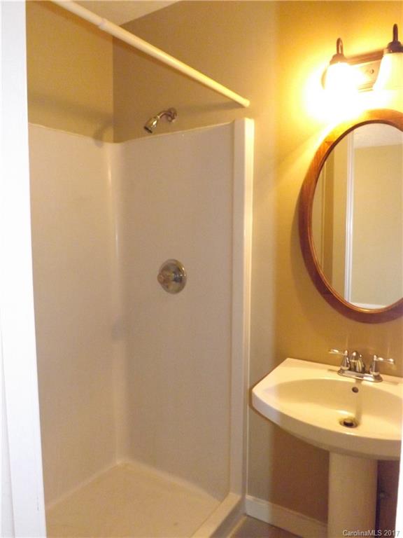 6019 Davis Road Waxhaw, NC 28173 - Photo 18 of 19 a bathroom with a sink a mirror and a shower