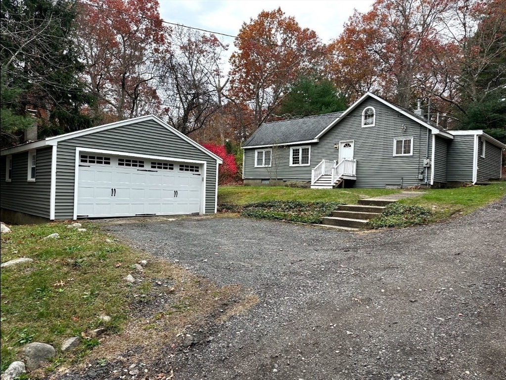 359 Mansfield Street, Unit 1 Sharon, MA 02067 - Photo 2 of 14 a front view of a house with a yard and garage