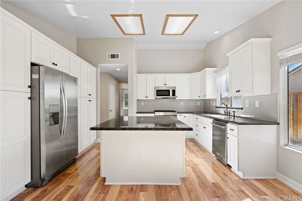 43345 Via Sabino Temecula, CA 92592 - Photo 9 of 22 a kitchen with stainless steel appliances granite countertop a refrigerator a sink dishwasher a stove and white countertops with wooden floor