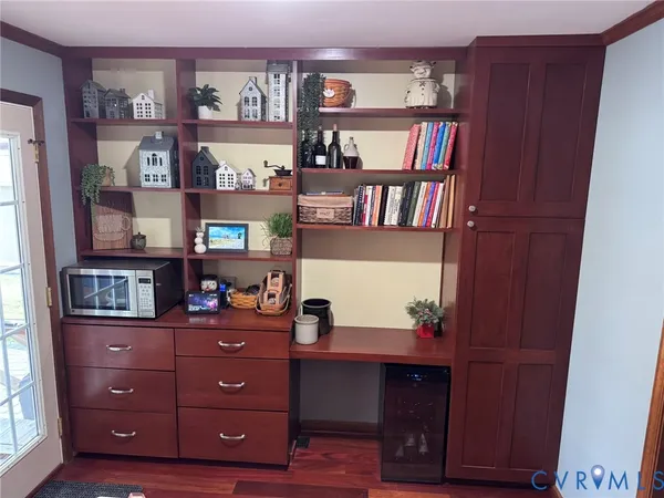 a room with wooden floor and lots of frames on wall