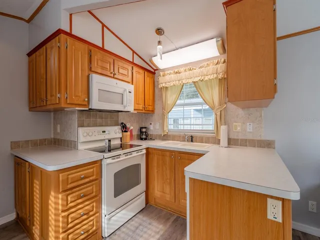 a kitchen with stainless steel appliances granite countertop a sink a stove and a refrigerator