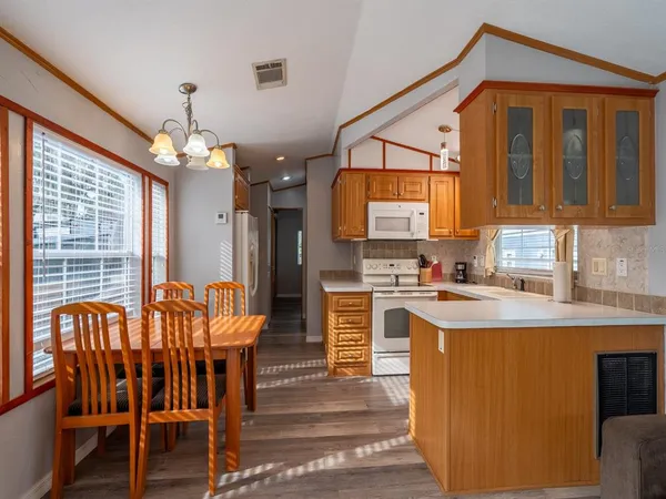 a kitchen with cabinets a sink dining table and chairs