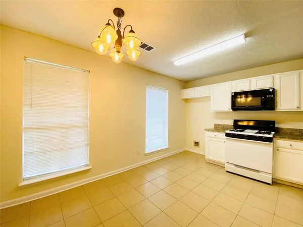 a kitchen with stainless steel appliances a stove a microwave and white cabinets