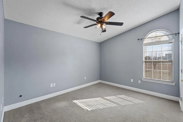 a view of a big room with windows and chandelier fan