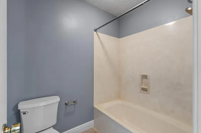 a white bath tub sitting next to a toilet
