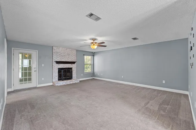 an empty room with a fireplace and a window