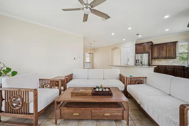 a living room with furniture and a view of kitchen