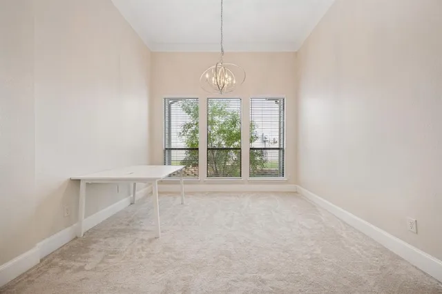 an empty room with ceiling fan and window