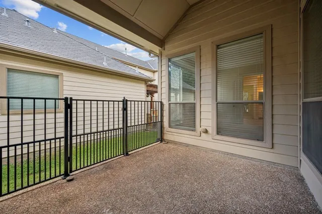 a view of a house with a small yard and a large tree