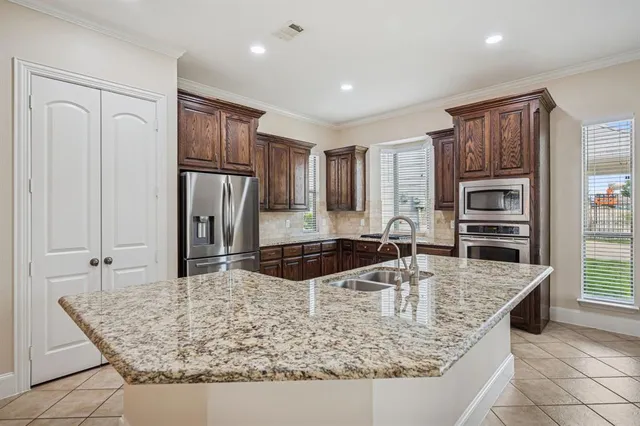 a kitchen with stainless steel appliances granite countertop a sink refrigerator and cabinets