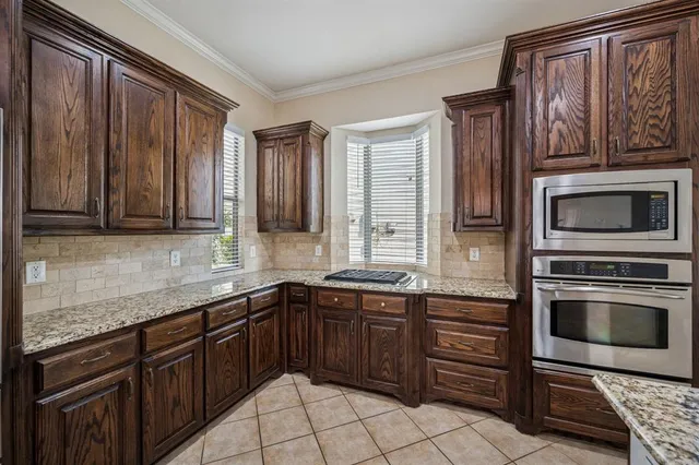 a kitchen with stainless steel appliances granite countertop a sink and stove top oven