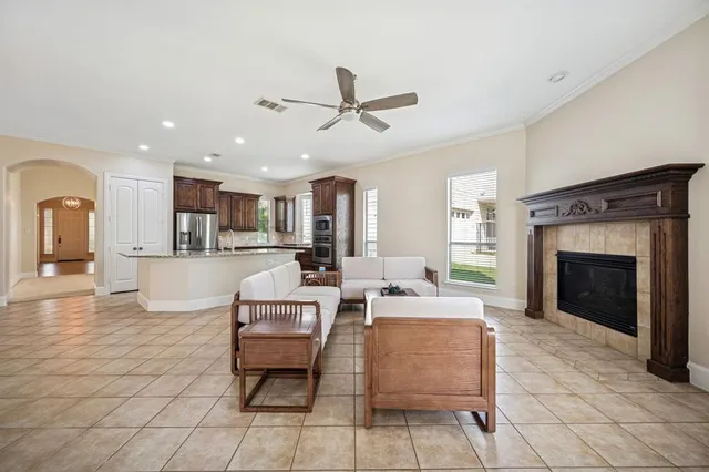 a living room with furniture a fireplace and a kitchen view