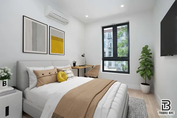 a bedroom with a bed and a potted plant