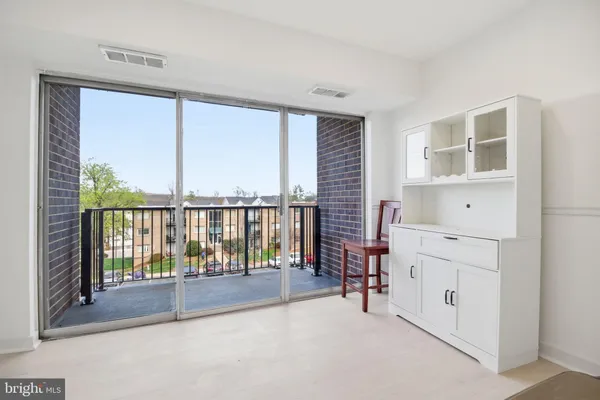 a view of a kitchen with refrigerator and white cabinets