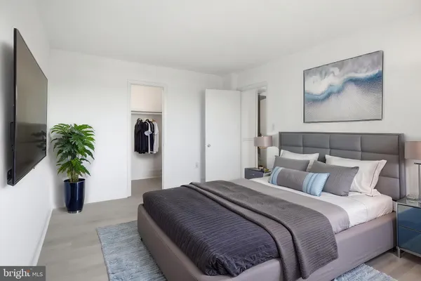 a bedroom with a large bed and a potted plant