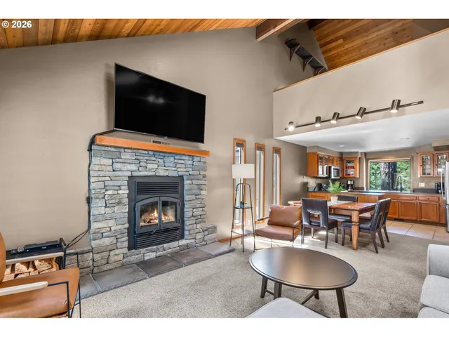 a living room with furniture a flat screen tv and kitchen view