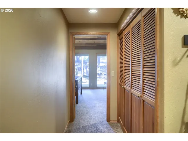 a view of a hallway with wooden floor and a dining room