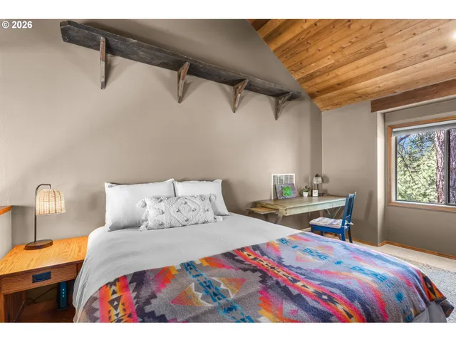 a bedroom with a bed a table and painting