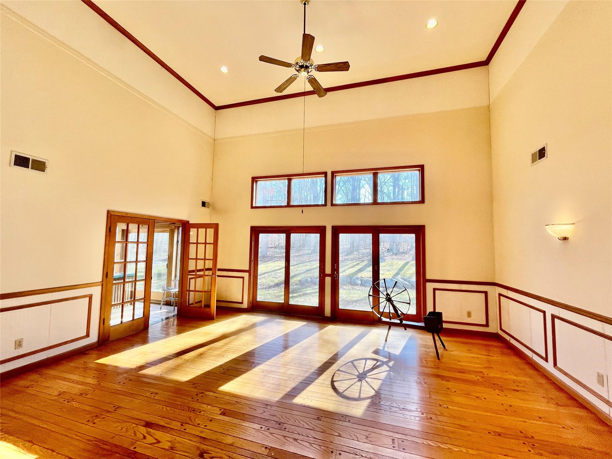 71 Saddleback Ridge Wallkill, NY 12589 - Photo 9 of 39 Unfurnished living room featuring french doors, light wood-type flooring, ornamental molding, a ceiling fan, and a decorative wall