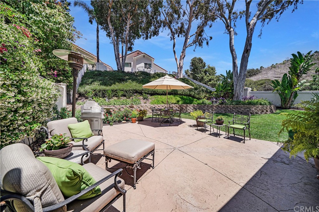 19 Springbrook Road Laguna Niguel, CA 92677 - Photo 27 of 41 a view of a patio with chairs and table under an umbrella