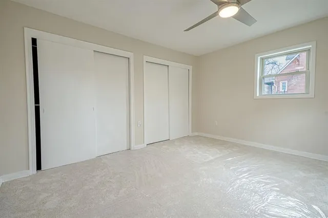 an empty room with closet and windows