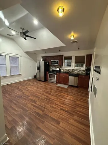 a large kitchen with stainless steel appliances granite countertop a stove and a refrigerator